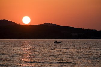 Acharavi, rybář při západu slunce